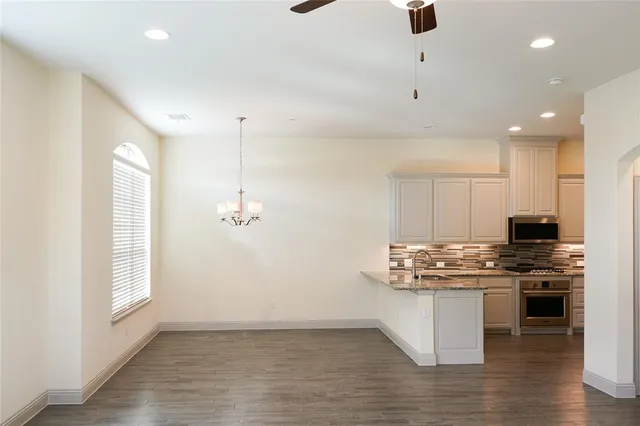 a kitchen with stainless steel appliances kitchen island granite countertop a stove a sink and a refrigerator