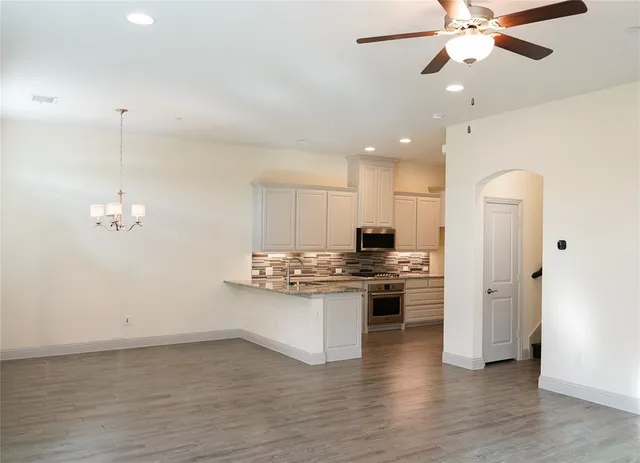 a kitchen with stainless steel appliances a stove top oven a sink a refrigerator and cabinets