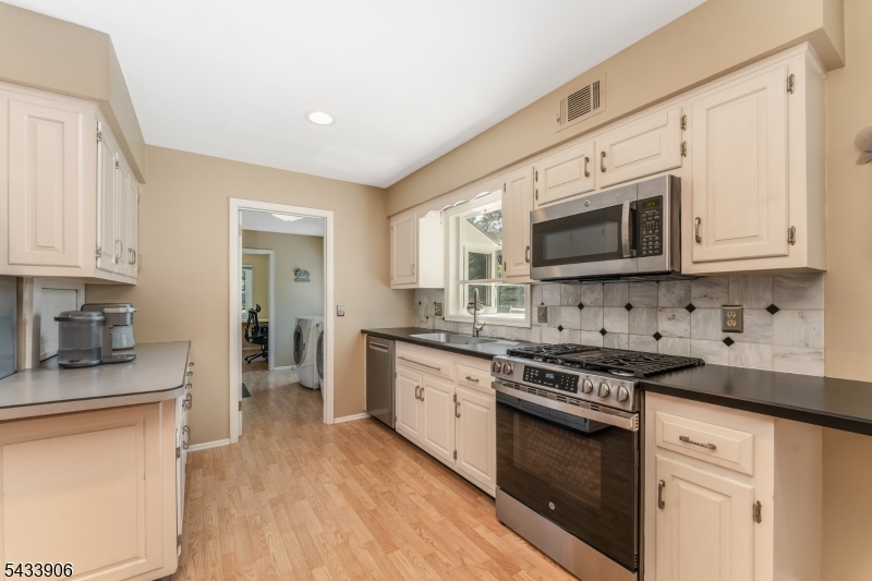 14 Lexington Road Annandale, NJ 08801 - Photo 11 of 47 a kitchen with stainless steel appliances granite countertop a stove top oven a sink dishwasher and a microwave oven with white cabinets