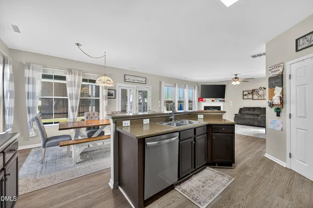 a dining room with furniture a chandelier and wooden floor
