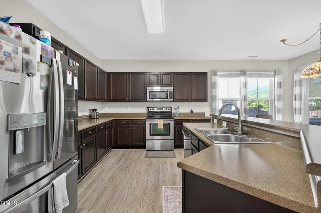 a kitchen with kitchen island a sink stove and refrigerator