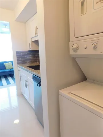 a kitchen with stainless steel appliances granite countertop a sink a stove and white cabinets