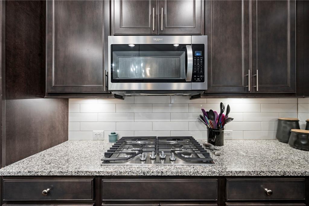 6780 Rambling Vale Dawsonville, GA 30534 - Photo 13 of 53 a kitchen with granite countertop a stove a microwave a sink and cabinets