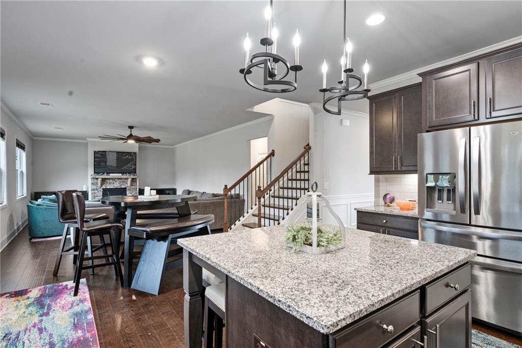 6780 Rambling Vale Dawsonville, GA 30534 - Photo 15 of 53 a kitchen with stainless steel appliances kitchen island granite countertop a table chairs and stove