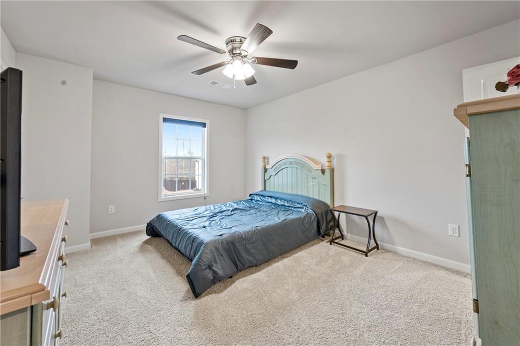 6780 Rambling Vale Dawsonville, GA 30534 - Photo 38 of 53 a bedroom with a bed and a chandelier