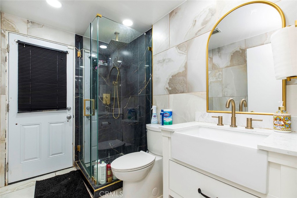 18810 Kirkcolm Lane Porter Ranch, CA 91326 - Photo 24 of 75 a bathroom with a sink a toilet a shower and a mirror
