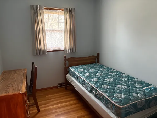a bedroom with wooden bed and a window