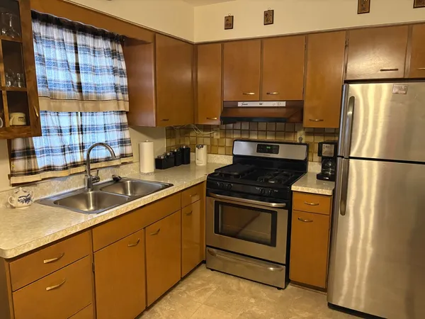 a kitchen with stainless steel appliances granite countertop a stove a refrigerator and a sink