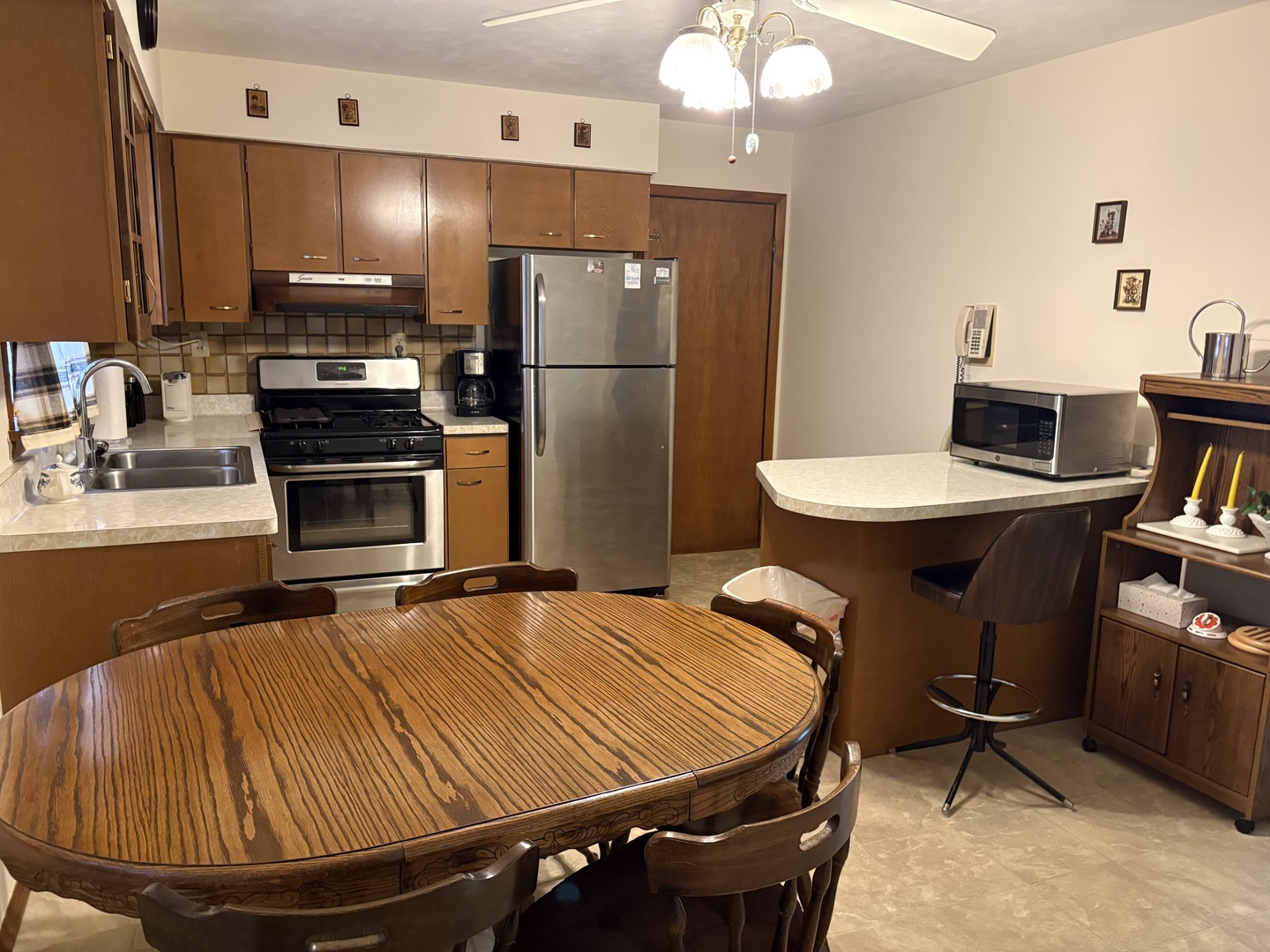 215 Phyllis Avenue Rochelle, IL 61068 - Photo 5 of 27 a room with kitchen island a appliances dining table chairs and a refrigerator