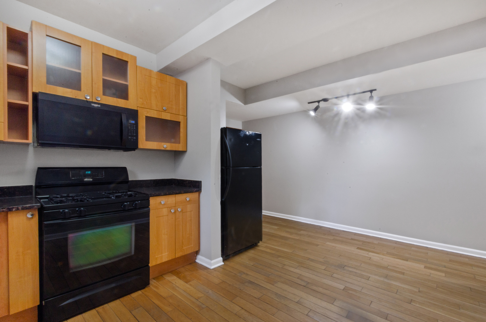 3908 West Ainslie Street, Unit G Chicago, IL 60625 - Photo 7 of 16 a kitchen with granite countertop wooden cabinets and a stove top oven