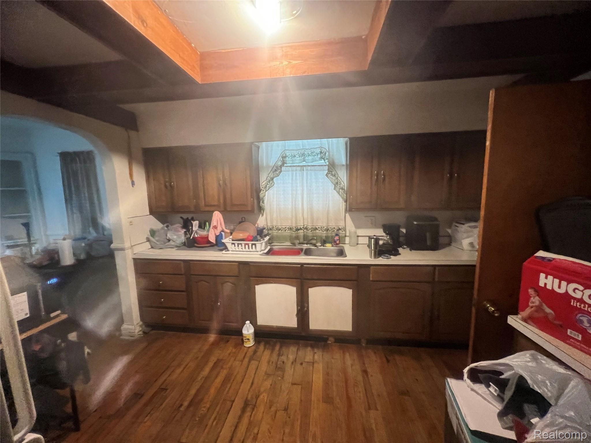 17311 Santa Rosa Drive Detroit, MI 48221 - Photo 35 of 89 Kitchen featuring wood-finish flooring, wood cabinetry with gold-tone hardware, and exposed wood ceiling beams