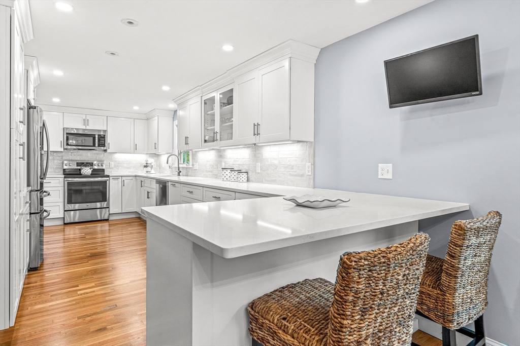 2 Longfellow Road Wellesley, MA 02481 - Photo 6 of 28 a kitchen with stainless steel appliances kitchen island granite countertop a sink and a white cabinets