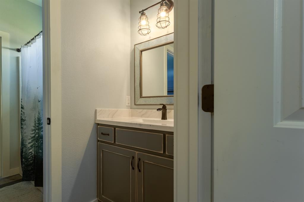 14910 Old Stoney Road Ponder, TX 76259 - Photo 27 of 36 a bathroom with a sink and a mirror