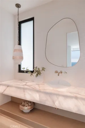 a bathroom with a sink a potted plant and a mirror