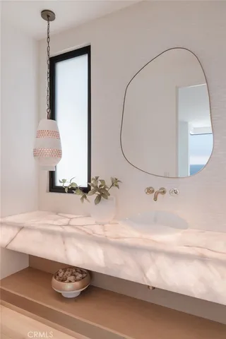 a bathroom with a sink a potted plant and a mirror