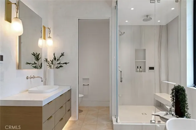 a large white kitchen with a refrigerator a sink and white cabinets