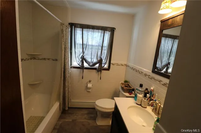 a bathroom with a sink a toilet and shower curtain