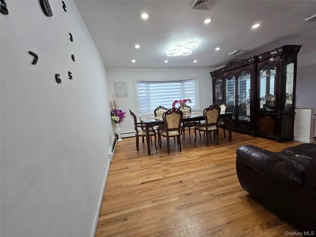 a living room with furniture a wooden floor and next to a window