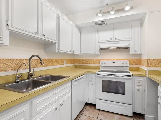 a kitchen with stainless steel appliances white cabinets and white appliances