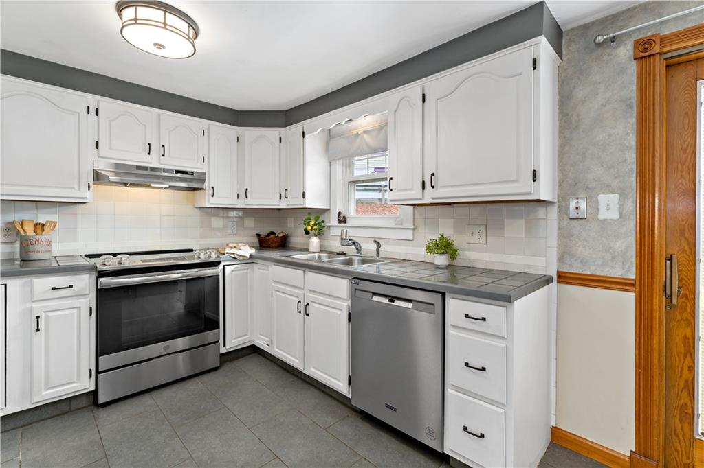 3181 Mellott Road Pittsburgh, PA 15227 - Photo 10 of 34 a kitchen with granite countertop white cabinets and white appliances