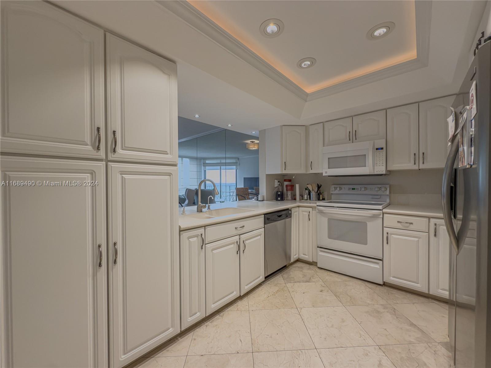 520 Brickell Key Drive, Unit A705 Miami, FL 33131 - Photo 11 of 66 a kitchen with white cabinets and white appliances