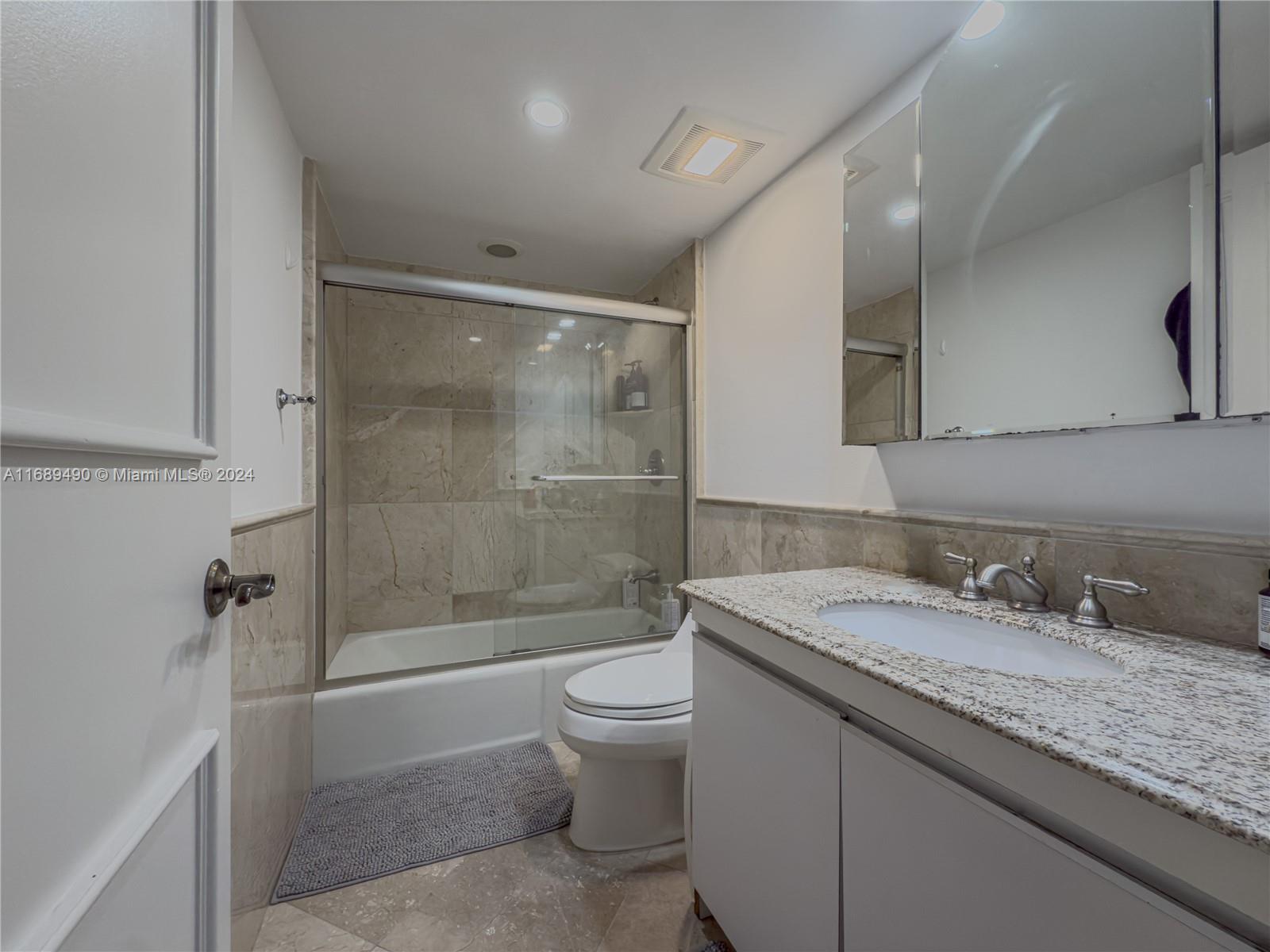 520 Brickell Key Drive, Unit A705 Miami, FL 33131 - Photo 16 of 66 a bathroom with a granite countertop sink a toilet and shower