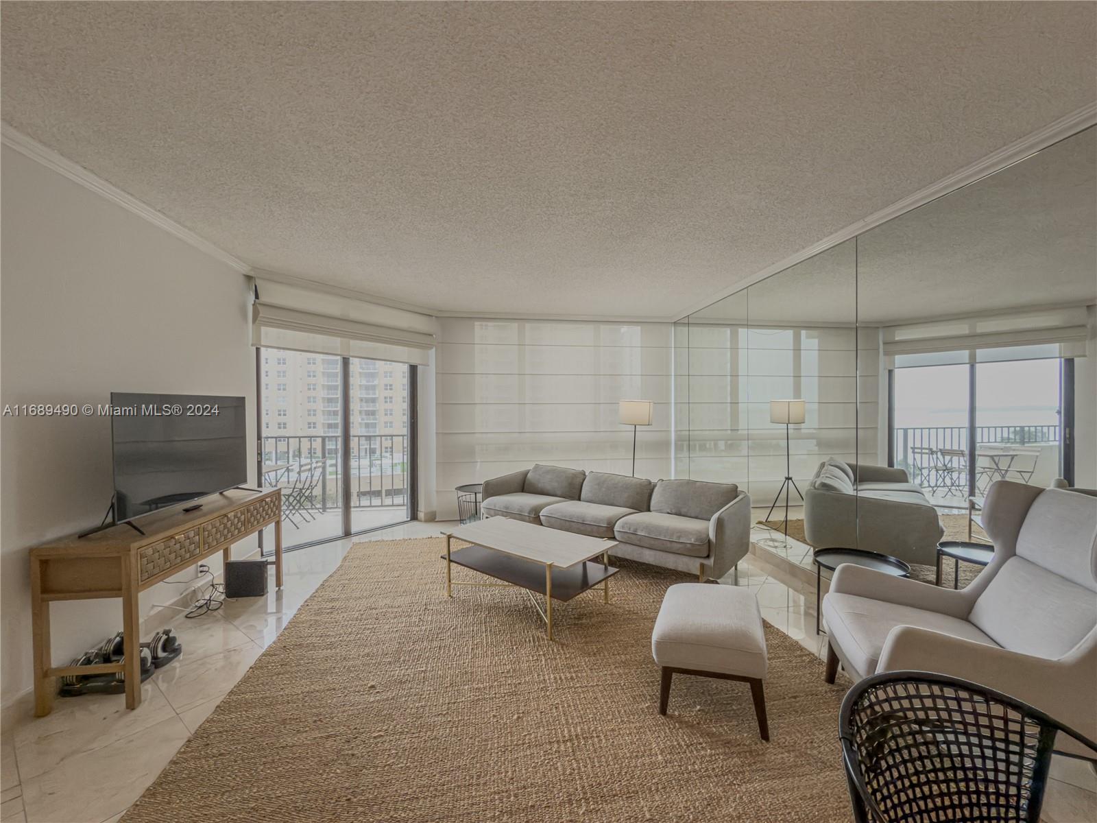 520 Brickell Key Drive, Unit A705 Miami, FL 33131 - Photo 2 of 66 a living room with furniture a flat screen tv and a window