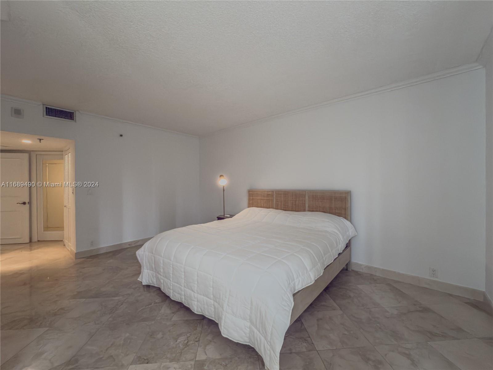520 Brickell Key Drive, Unit A705 Miami, FL 33131 - Photo 22 of 66 a large bed sitting in a bedroom next to a cabinet