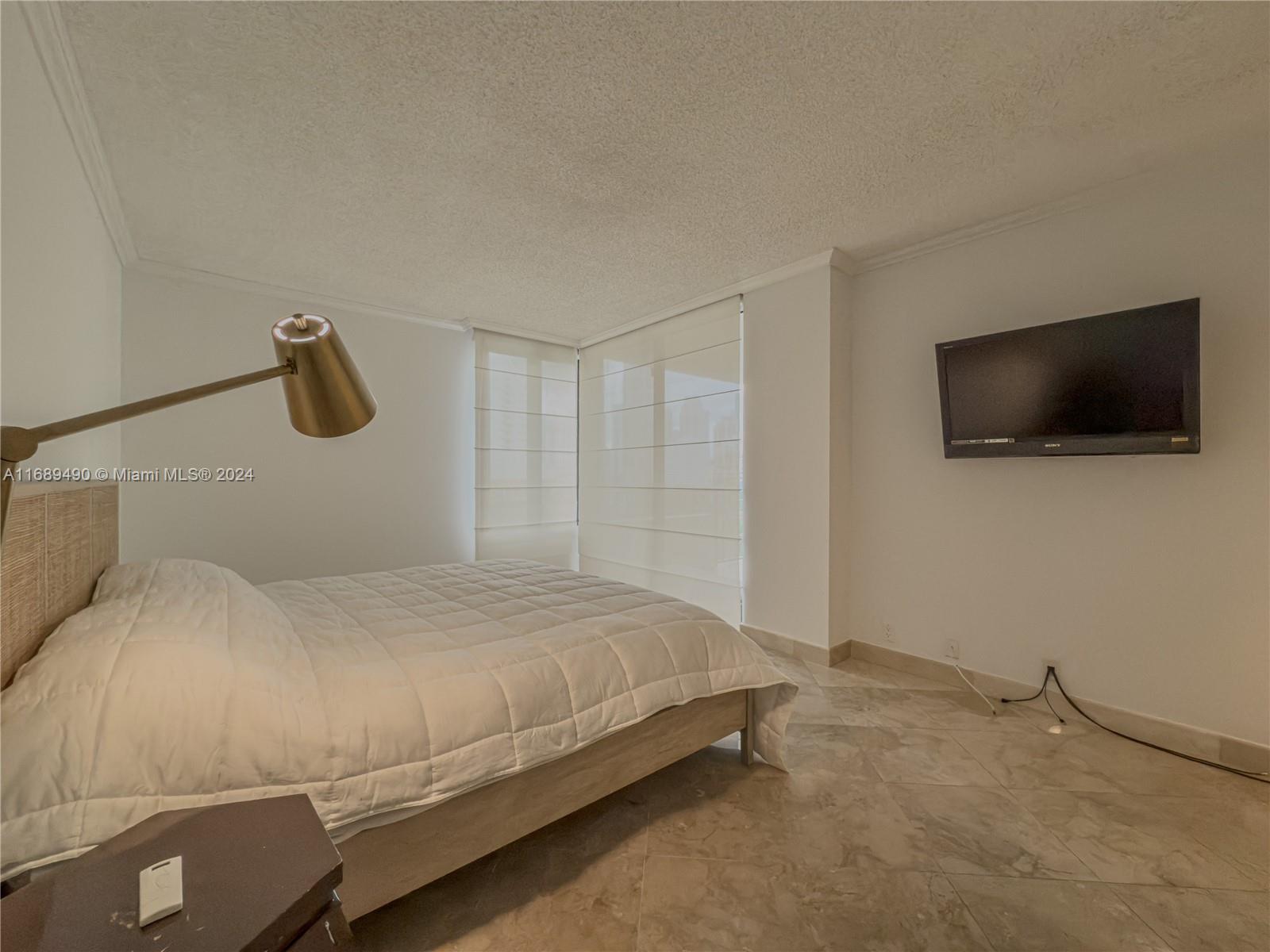 520 Brickell Key Drive, Unit A705 Miami, FL 33131 - Photo 25 of 66 a bedroom with a bed and a flat screen tv