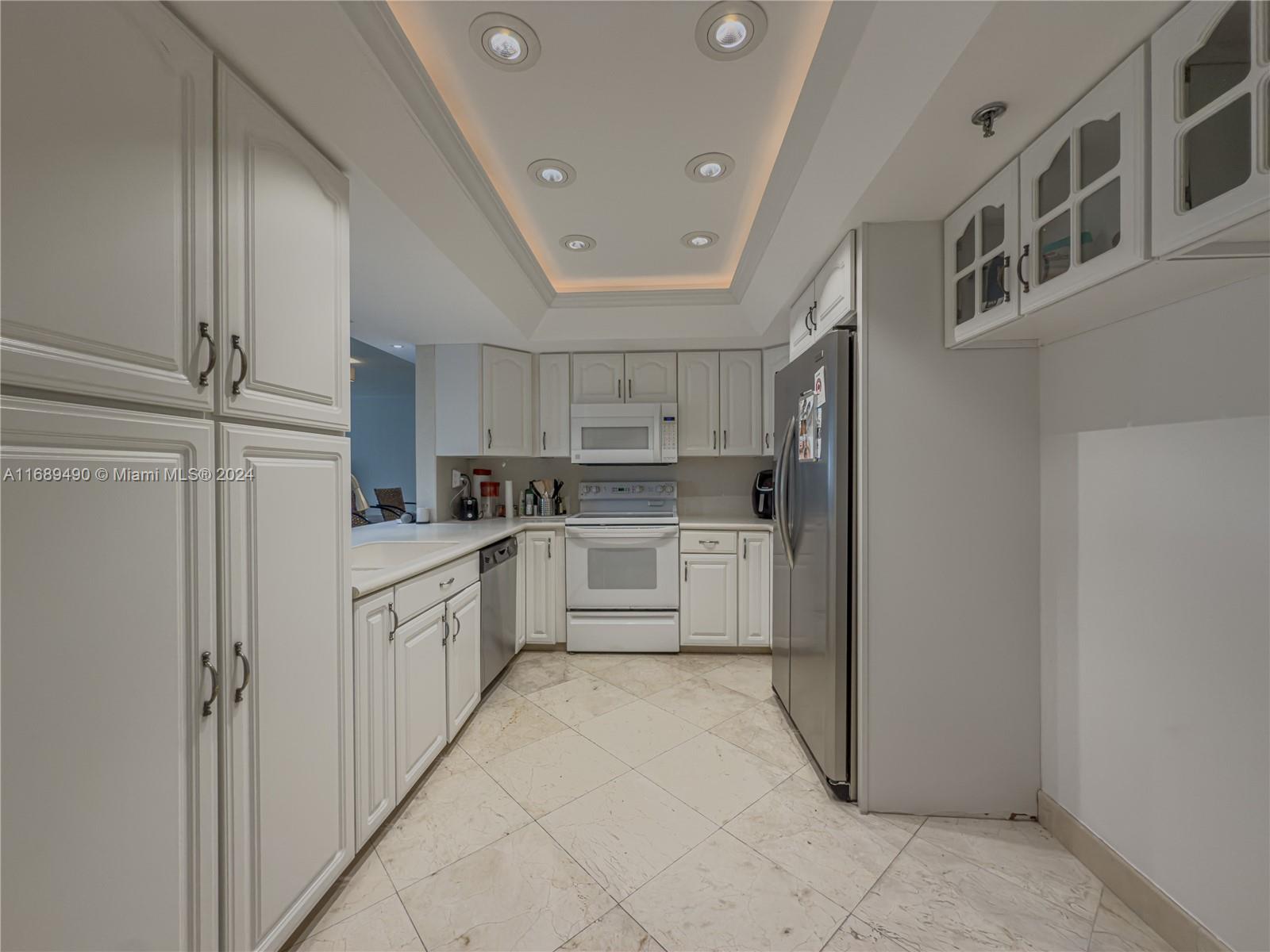 520 Brickell Key Drive, Unit A705 Miami, FL 33131 - Photo 10 of 66 a kitchen with stainless steel appliances granite countertop a refrigerator and white cabinets