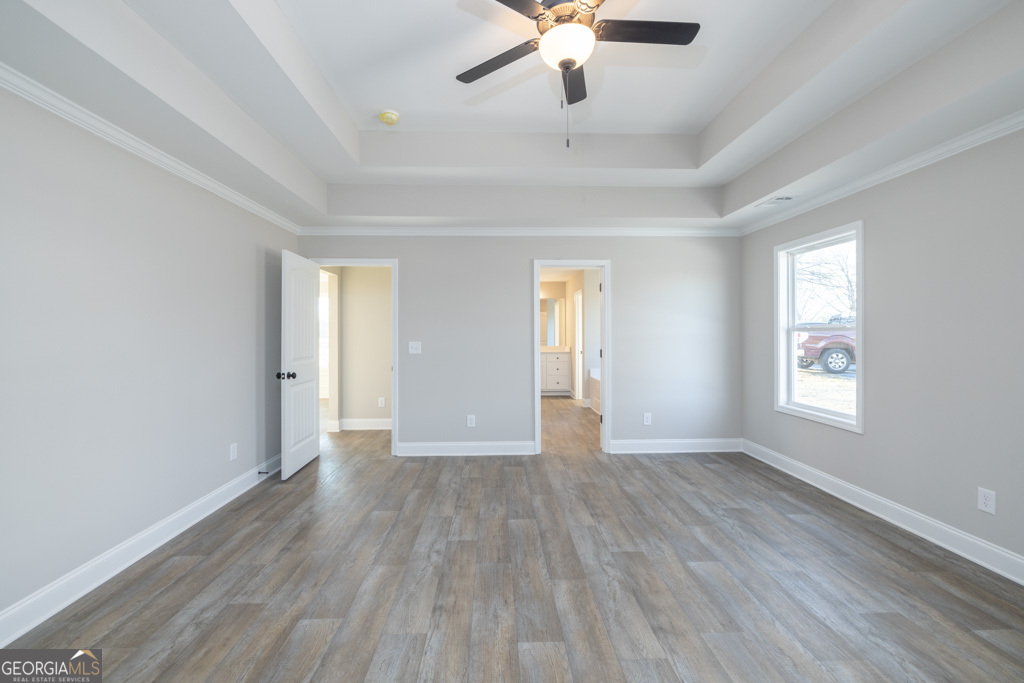 300 Grady Brock Road, Unit 20 Martin, GA 30557 - Photo 20 of 26 an empty room with wooden floor chandelier fan and windows