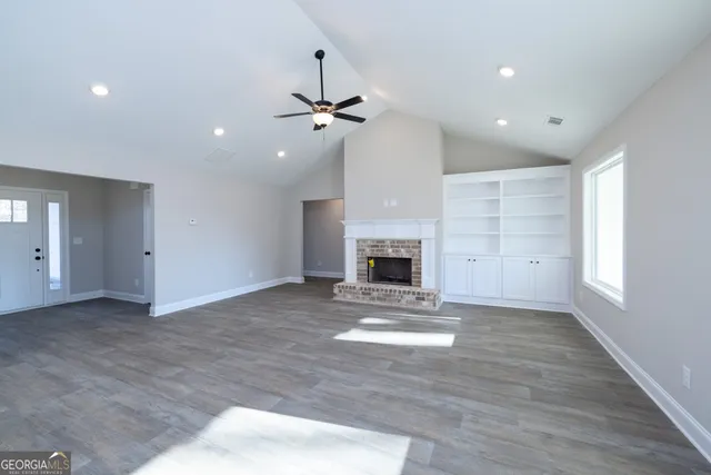 a kitchen with stainless steel appliances kitchen island granite countertop a stove a sink and white cabinets with wooden floor