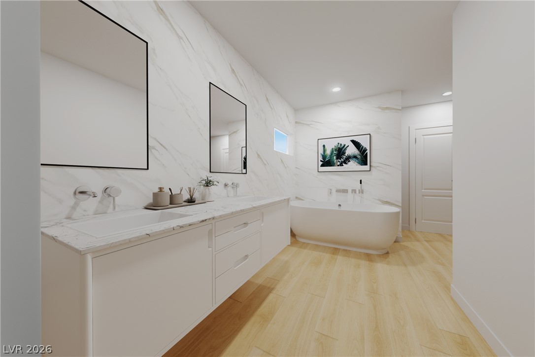 1140 Julie Road Henderson, NV 89002 - Photo 42 of 71 Virtually staged/remodeled. 1140 JULIE RD HENDERSON NV 89002. Marble-clad walls and light wood flooring define this elegant, serene primary bathroom with a freestanding soaking tub.