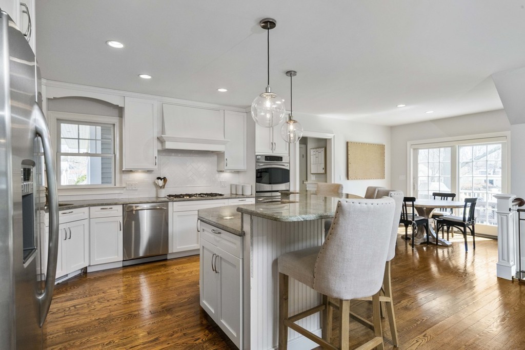 38 Smith Place Cohasset, MA 02025 - Photo 8 of 28 a large kitchen with kitchen island a dining table chairs and white cabinets