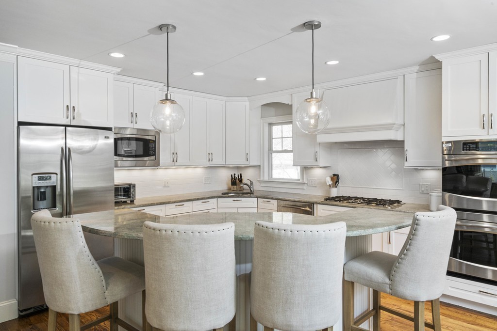 38 Smith Place Cohasset, MA 02025 - Photo 9 of 28 a kitchen with stainless steel appliances granite countertop a sink a stove a refrigerator and chairs