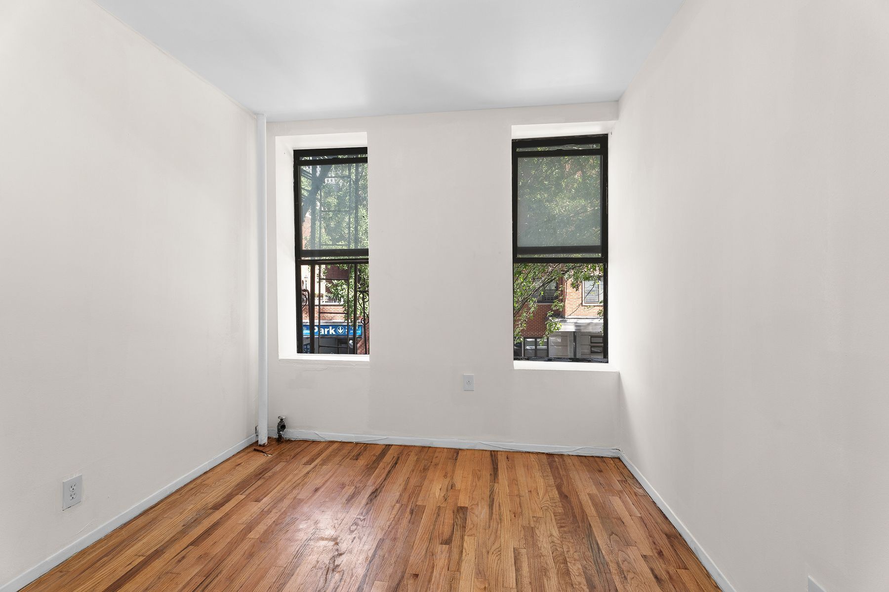 246 East 51st Street, Unit 7 Manhattan, NY 10022 - Photo 3 of 8 an empty room with wooden floor and windows