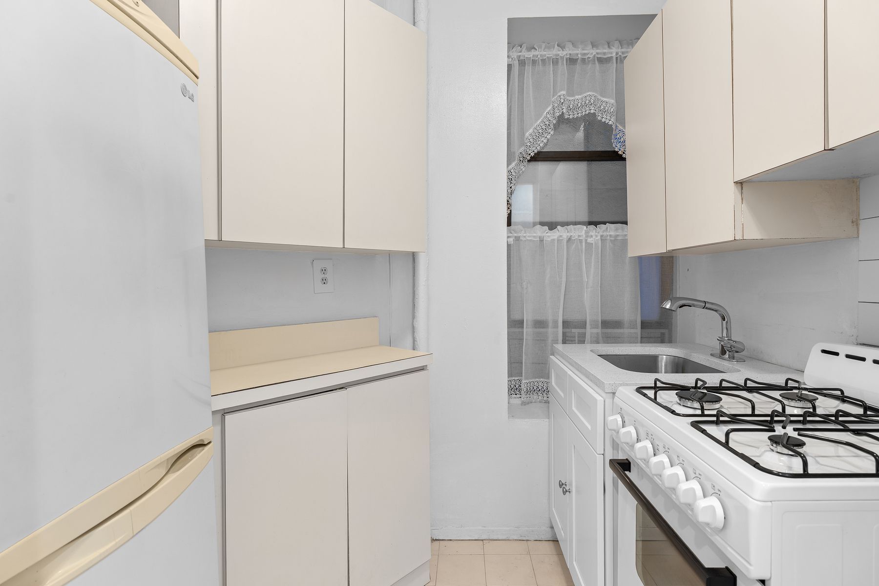 246 East 51st Street, Unit 7 Manhattan, NY 10022 - Photo 5 of 8 a kitchen with stainless steel appliances granite countertop a stove and a refrigerator