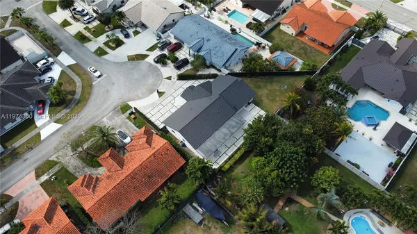an aerial view of a house with a garden and lake view