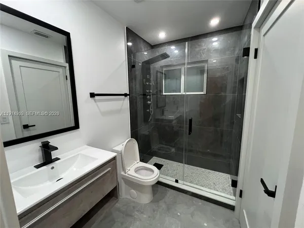 a bathroom with a bathtub shower sink and toilet