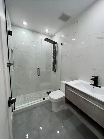 a bathroom with a sink a toilet and shower
