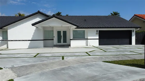 a front view of a house with a basket ball court and a fire pit