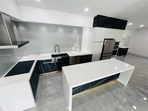 a kitchen with a sink a wooden floor and chairs