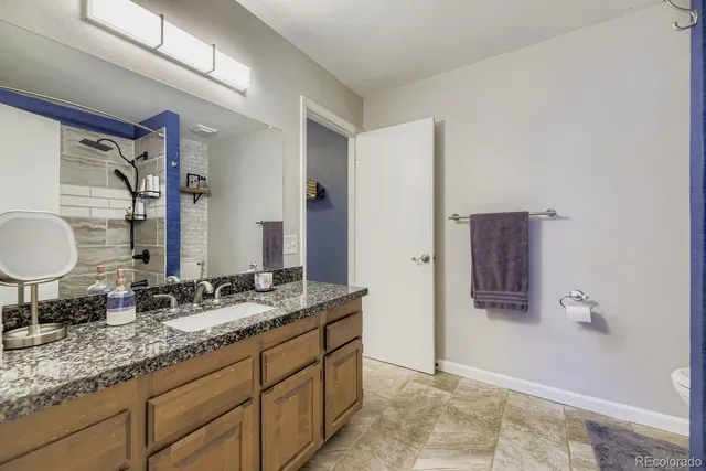 a bathroom with a granite countertop sink and a mirror