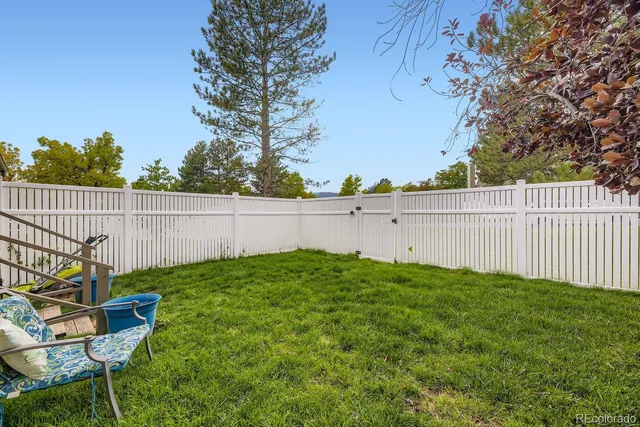 a view of backyard with wooden fence