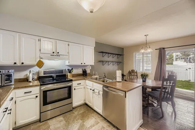a kitchen with a stove white cabinets and white appliances