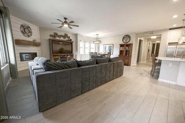 a dinning room with kitchen island furniture a stove a sink and a large window