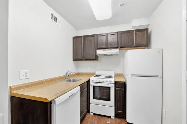 a kitchen with a sink a stove a refrigerator and a microwave