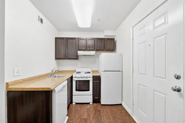 a kitchen with a sink a stove a refrigerator and cabinets