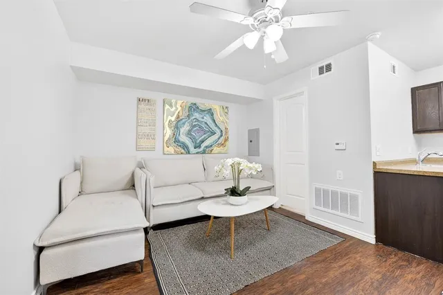 a living room with furniture a large window and a chandelier
