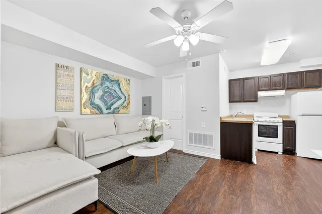 a living room with furniture and a kitchen